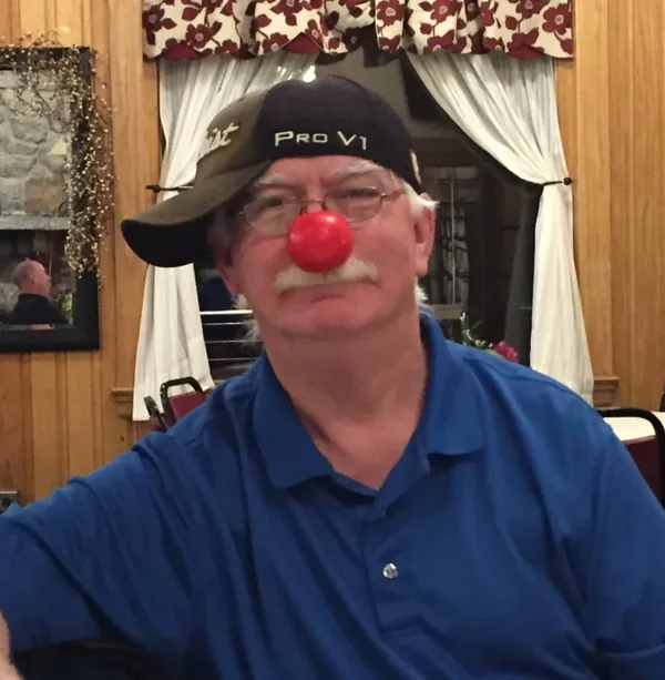 Rick Comfort, smiling, in a golf cap